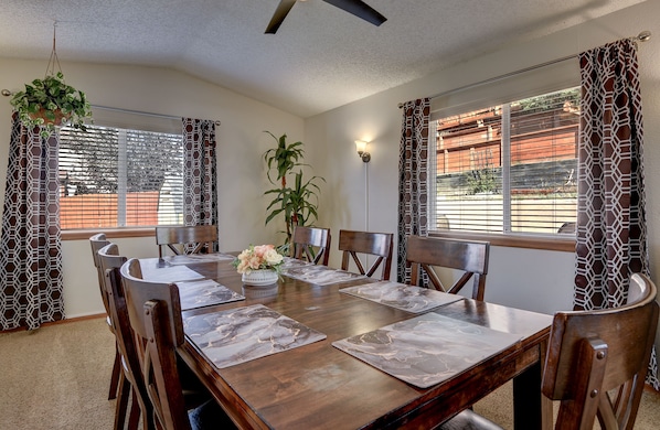 A dining room with a wooden table, chairs, and a potted plant. - Spacious 5 BDR 3 BA House with Hot Tub, BBQ, Fire Pit, Home Gym, Mountain View (Colorado Springs)