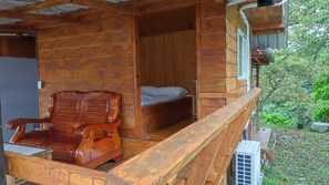 A wooden cabin with a balcony, a wooden chair, and a bed. - chargevillage (Jiaoxi)