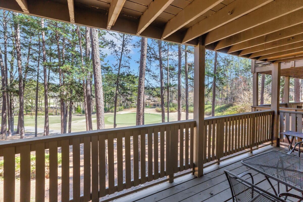 A covered outdoor area with a view of a golf course.