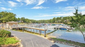 A marina with boats docked, a pedestrian bridge, and a small building on the left.