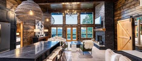 Una cocina moderna con una isla grande, taburetes de bar y una chimenea.