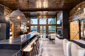 Una cocina moderna con una isla grande, taburetes de bar y una chimenea.