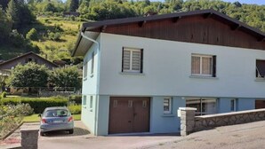 Et toetagers hus med garage, indkørsel og en murstensmur foran.