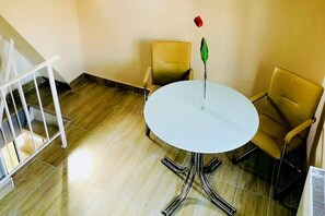 A room with a round table, two chairs, a white railing, and a staircase. - Apartment in Gammertingen with terrace (Gammertingen)