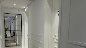 A hallway with white paneled walls and a wooden floor. - Apartamentos Turísticos La Plaza (Chipiona)