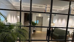 A modern interior with a large sliding glass door leading to a living area. - Apartamentos Turísticos La Plaza (Chipiona)
