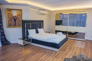 A modern bedroom with a large bed, a bedside table, a mirror, and a painting on the wall. - Calm In Sapanca (Sapanca)