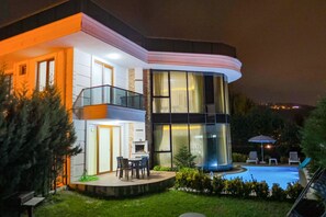 A modern two-story house with a swimming pool, a balcony, and a well-lit outdoor area. - Calm In Sapanca (Sapanca)