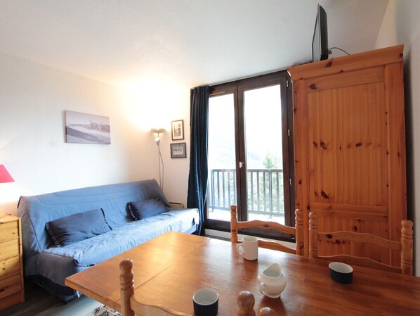 Enjoy meals at the dining table for two, with a sofa and chair nearby, and take in the view from the large window.