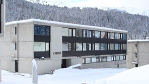 Un bâtiment moderne doté d’un toit plat, de grandes fenêtres et du nom « CAPELLA » inscrit sur la façade.