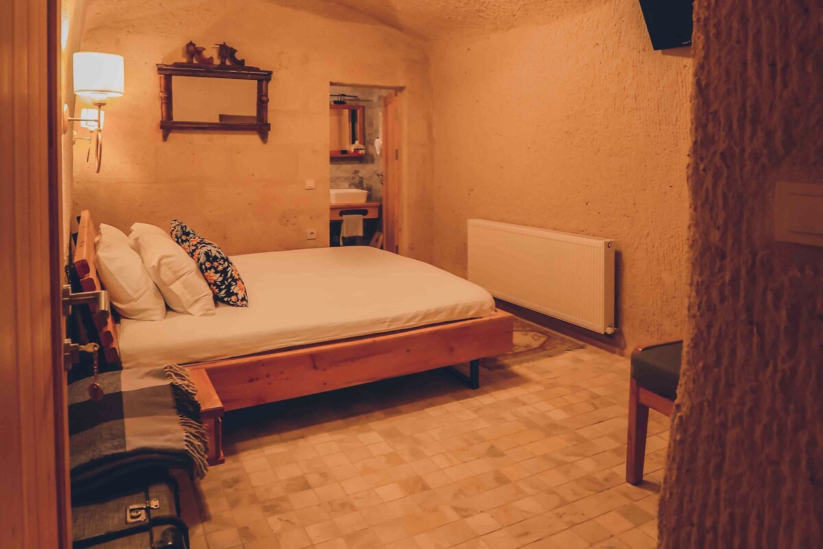 Un dormitorio con cama, cómoda, lámpara y radiador.
