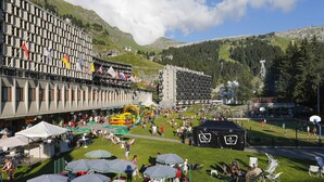 Un hôtel à étages, doté d’une terrasse et offrant une vue sur les montagnes.