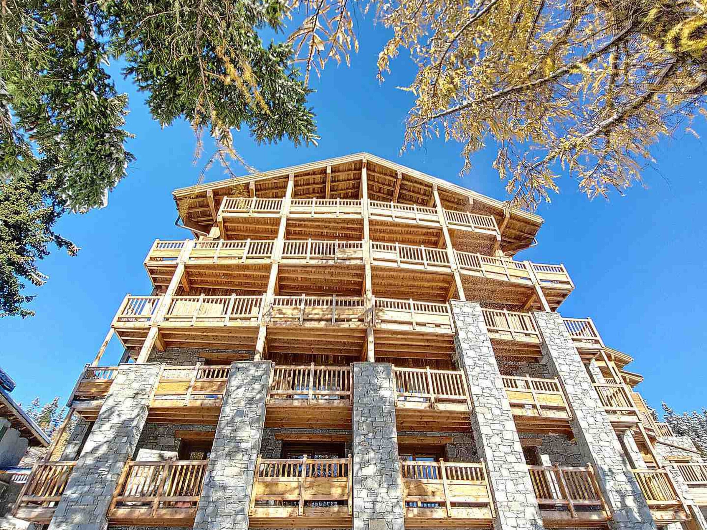 A multi-story building with wooden balconies and stone pillars.