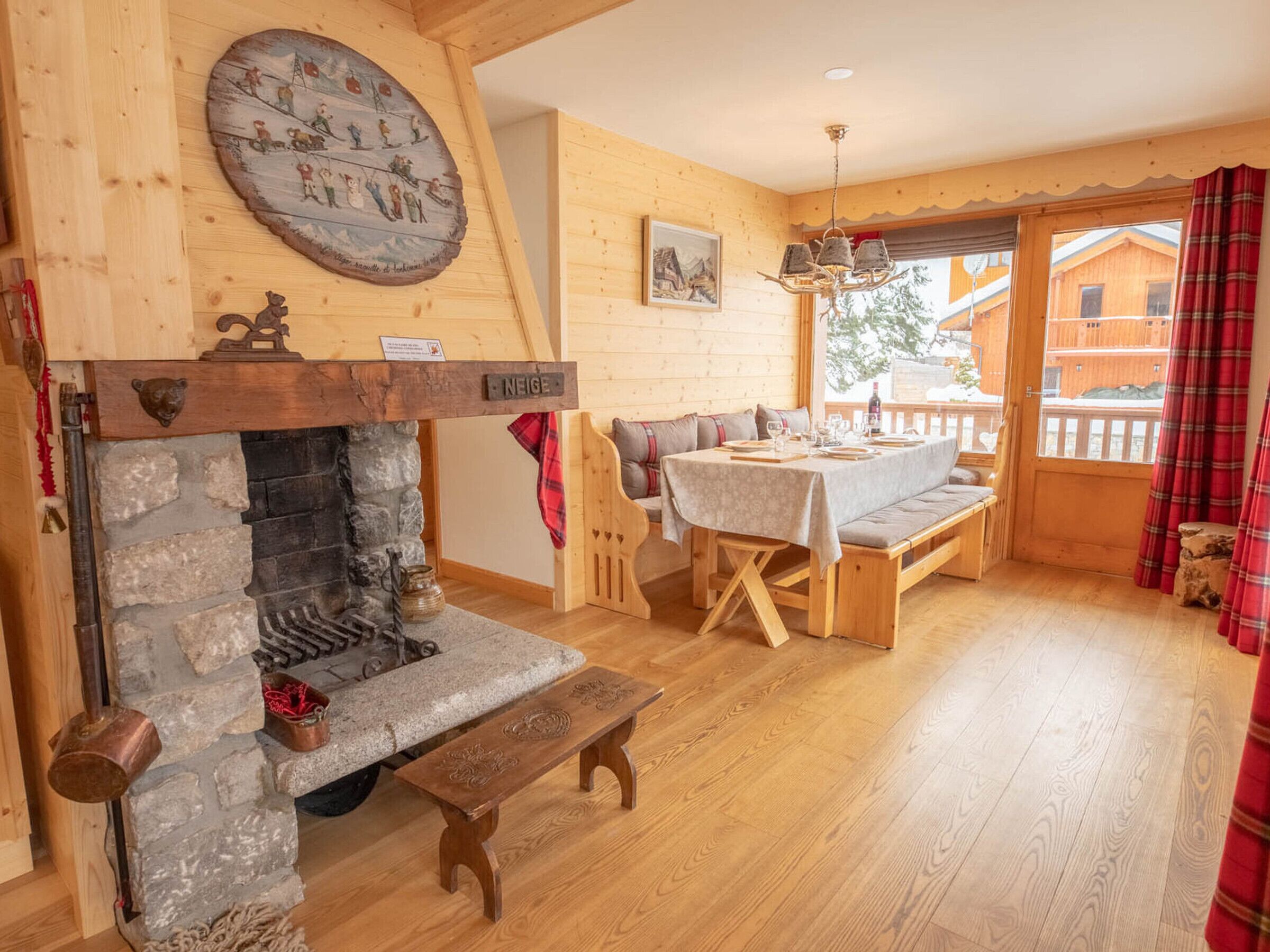 A cozy room with a stone fireplace, wooden bench, and a dining table set for two.