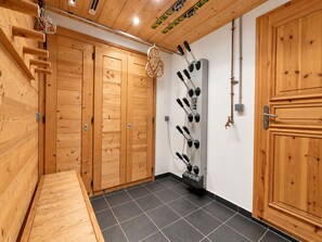 A wooden interior with a sauna, a massage table, and a wall-mounted massage chair.