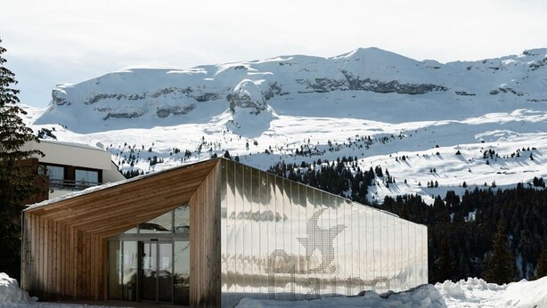 A modern building with a wooden sloped roof and large glass windows, set against a snowy mountain backdrop. - Renovated Studio for 4, South-Facing Balcony, Close to Slopes & Shops (Flaine)