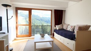 Een moderne kamer met een bank, een tafeltje en een televisie.