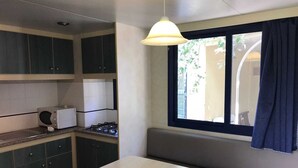 A compact kitchen with dark cabinets, a white countertop, a microwave, and a gas stove. - VACATION HOME VILLAGE MORESCO PESCHICI GARGANO (Peschici)