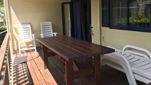 A covered outdoor area with a wooden table and two white chairs. - VACATION HOME VILLAGE MORESCO PESCHICI GARGANO (Peschici)