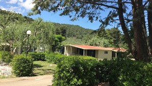 A building with a red roof, surrounded by lush greenery and trees. - VACATION HOME VILLAGE MORESCO PESCHICI GARGANO (Peschici)