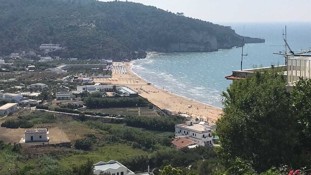 A coastal town with a beach, buildings, and a hilly backdrop. - VACATION HOME VILLAGE MORESCO PESCHICI GARGANO (Peschici)