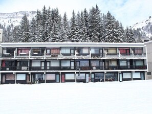 A multi-story building with balconies, surrounded by snow-covered trees and a mountainous backdrop. - Ski-In/Ski-Out Studio at Flaine, Sleeps 4, South-Facing Terrace, Easy Access to Shops and Lifts (Flaine)