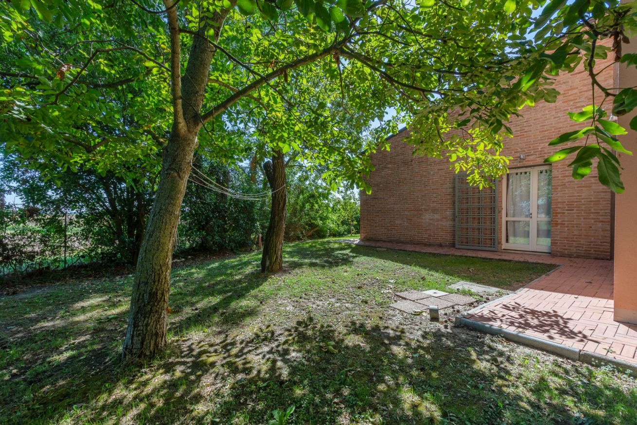 A brick building with a paved pathway leading to a door.