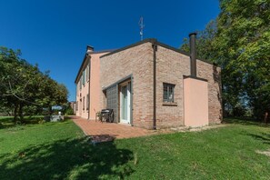 Un bâtiment en briques doté d’une porte, de fenêtres et d’une cheminée.