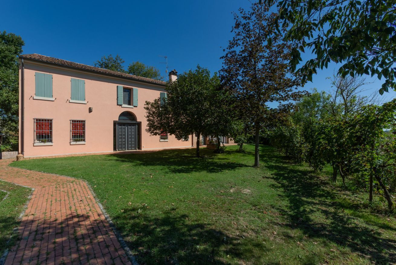 A two-story building with a paved driveway, a door, and windows.