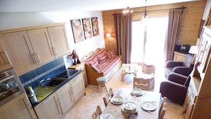 Un espacio habitable pequeño con kitchenette, comedor y asientos.