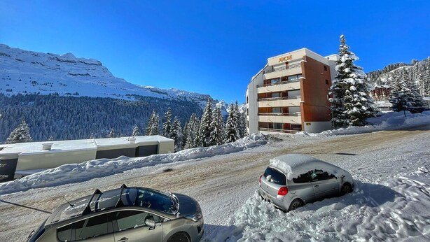 A building with the sign "ARCHE" on the top, surrounded by snow-covered trees and mountains. - Cozy Studio for 5, Near Ski Lift and Shops, South-Facing Balcony, Flaine Forest - Doris Residence (Flaine)