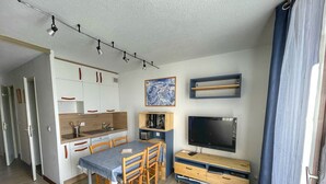 A compact living space with a kitchenette, dining area, and a TV. - Cozy Studio for 5, Near Ski Lift and Shops, South-Facing Balcony, Flaine Forest - Doris Residence (Flaine)
