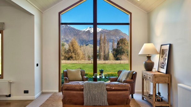 A living room with a large window offering a mountain view.