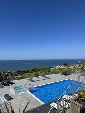 A swimming pool with a view of the ocean, outdoor seating, and a patio area. - Barmouth Pet-friendly 2-bed Caravan With Sea View (Barmouth)