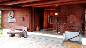 Puinen rakennus, jossa on kyltti, jossa lukee ”Biberchalet” ja ”Treppe zum Biberbau”.