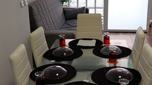 A dining area with a glass table set for four, surrounded by white chairs. - port of valence (València)