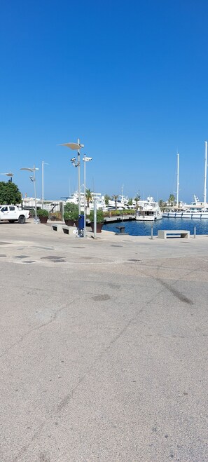 A marina with boats docked, a white truck, and a clear blue sky.