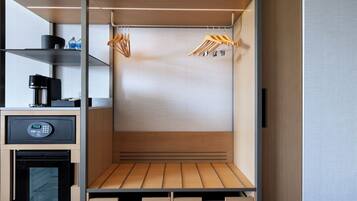 Una kitchenette compacta con cafetera, microondas y refrigerador pequeño.