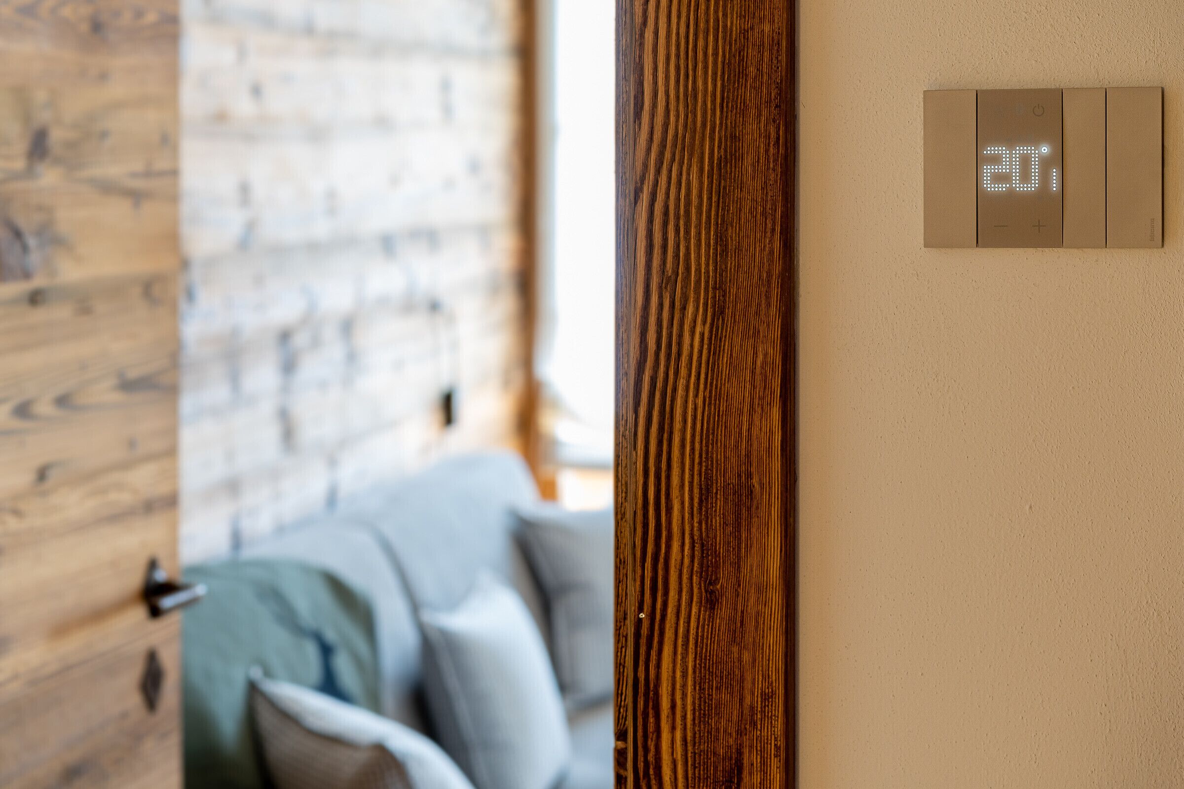 A wooden door with a digital thermostat displaying 20 degrees Celsius.