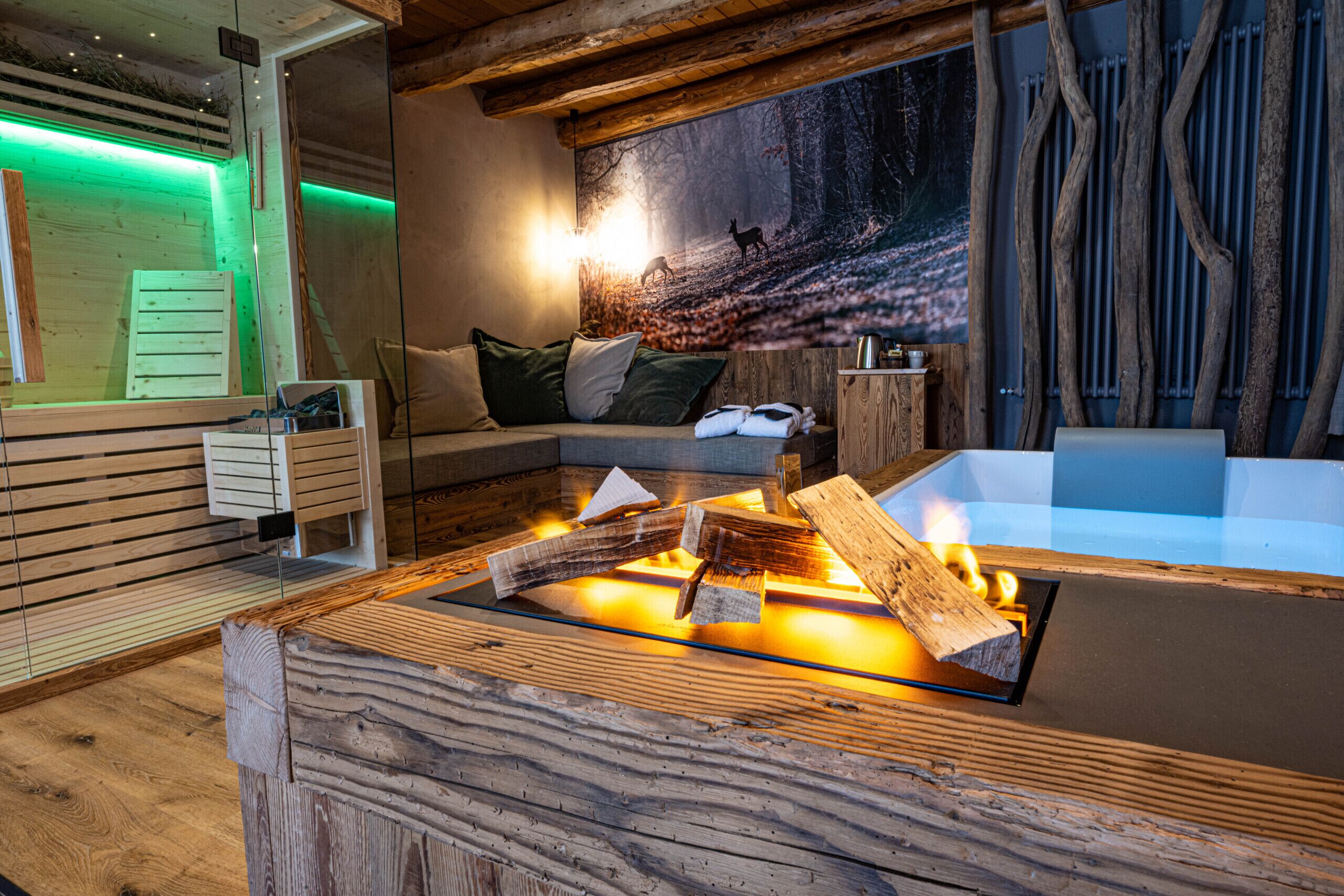 Una habitación acogedora con una chimenea de madera, un ventanal grande y una mesa de masaje fijada a la pared.