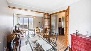 Un amplio salón con una mesa de comedor, sillas, un sofá y un aparador rojo.