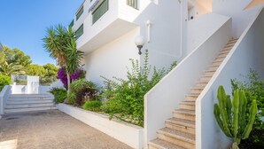 A white building with a staircase, a cactus, and various plants. - Apartment "Green Park B18" with Private Terraces, Shared Pool and Wi-Fi (Son Parc)