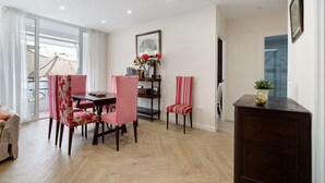 A dining area with a table, chairs, and a bookshelf.