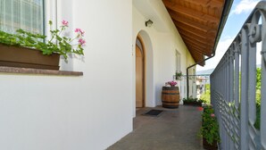 A corridor with a wooden ceiling, a white wall, a window with a mesh screen, and a metal fence. - Farmhouse "Valtlhof - Apt 2" with Shared Pool, Shared Garden & Wi-Fi (Cornaiano)