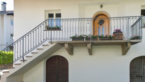 A building with a staircase leading to a balcony with potted plants and a wooden door. - Farmhouse "Valtlhof - Apt 2" with Shared Pool, Shared Garden & Wi-Fi (Cornaiano)