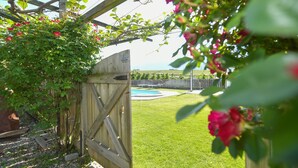 A wooden gate, a pool, and a grassy yard. - Farmhouse "Valtlhof - Apt 1" with Shared Pool, Shared Garden & Wi-Fi (Cornaiano)