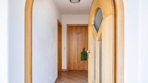 A hallway with a wooden door marked with the number 3, a green towel hanging on the door, and a tiled floor. - Farmhouse "Valtlhof - Apt 1" with Shared Pool, Shared Garden & Wi-Fi (Cornaiano)