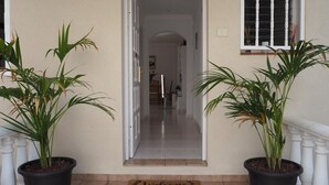 A house entrance with a door, a welcome mat, and two potted plants. - Vacation Home "Hibiscus" with Sea View, Pool & Wi-Fi (santa ursula)