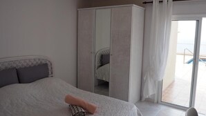 A bedroom with a bed, a wardrobe, and a sliding glass door leading to a balcony. - Vacation Home "Hibiscus" with Sea View, Pool & Wi-Fi (santa ursula)