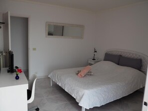 A bedroom with a bed, bedside table, and a mirror on the wall. - Vacation Home "Hibiscus" with Sea View, Pool & Wi-Fi (santa ursula)